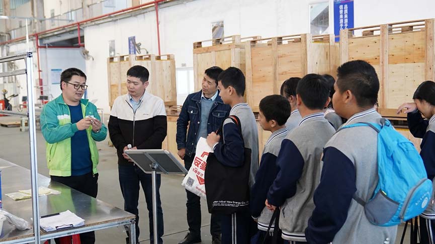 Mibet staff showing a mounting component to students in the workshop