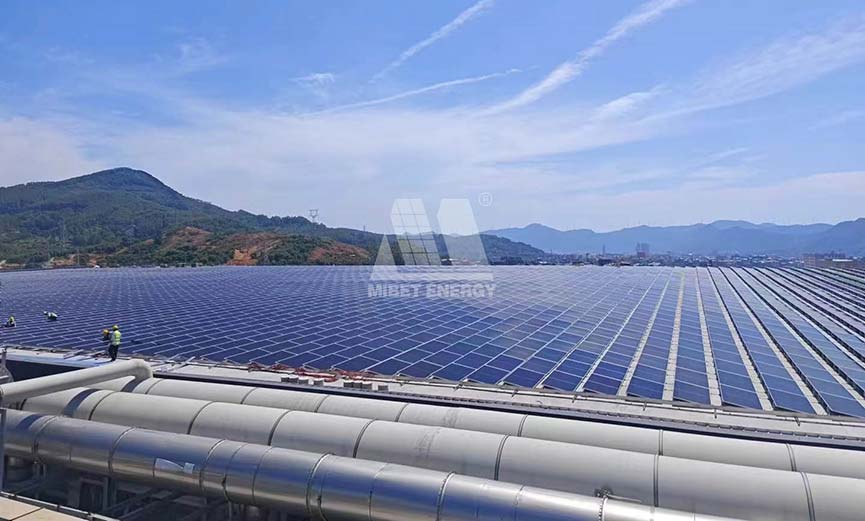 Expansive Mibet Energy rooftop solar array on BOE facility, mountains in background.