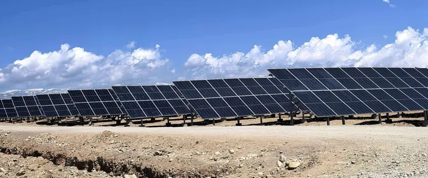 Utility-scale ground mount solar racking structure on rugged terrain.