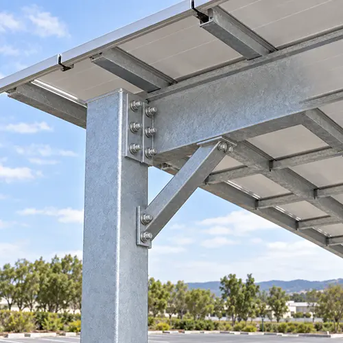 Bolted beam-to-column connection on a galvanized steel solar carport frame, with a bolted plate joining the main beam to the column head and a knee brace below.