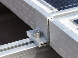 Aluminum solar panel end clamp with a stainless steel hex socket bolt, fastened to an aluminum rail at the edge of a module frame
